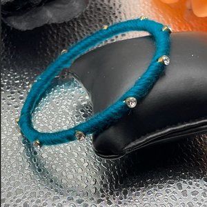 10.21.23.9 Turquoise colored yarn covered bracelet with rhinestones